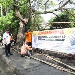 Petugas dan aparat Kelurahan Sukasari memasang spanduk larangan membuang sampah sembarangan di lokasi bekas TPS liar. (Foto: Ist)