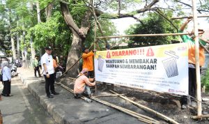 Petugas dan aparat Kelurahan Sukasari memasang spanduk larangan membuang sampah sembarangan di lokasi bekas TPS liar. (Foto: Ist)