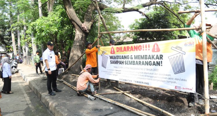 Petugas dan aparat Kelurahan Sukasari memasang spanduk larangan membuang sampah sembarangan di lokasi bekas TPS liar. (Foto: Ist)